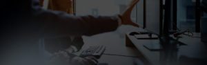A person is sitting at a desk with a keyboard.